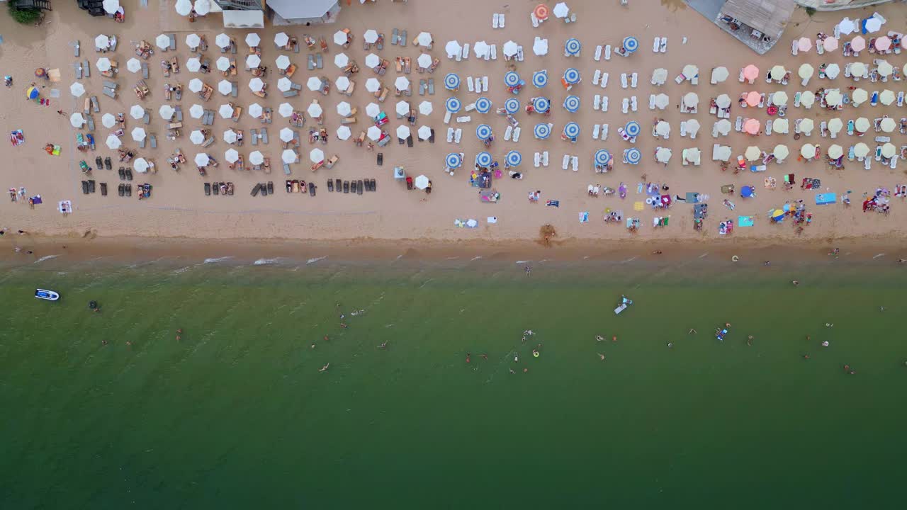 鸟瞰图，风景如画的海滩上，人们在海边享受阳光明媚的一天。理想的推广暑假，海滨度假胜地，和旅游经验。保加利亚黄金沙滩视频下载