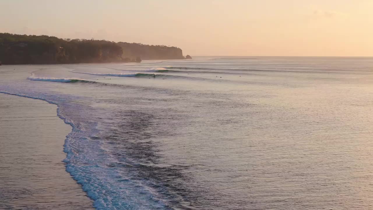 海岸线与海洋和完美的海浪在日落或日出。无人机拍摄的风景海景视频下载