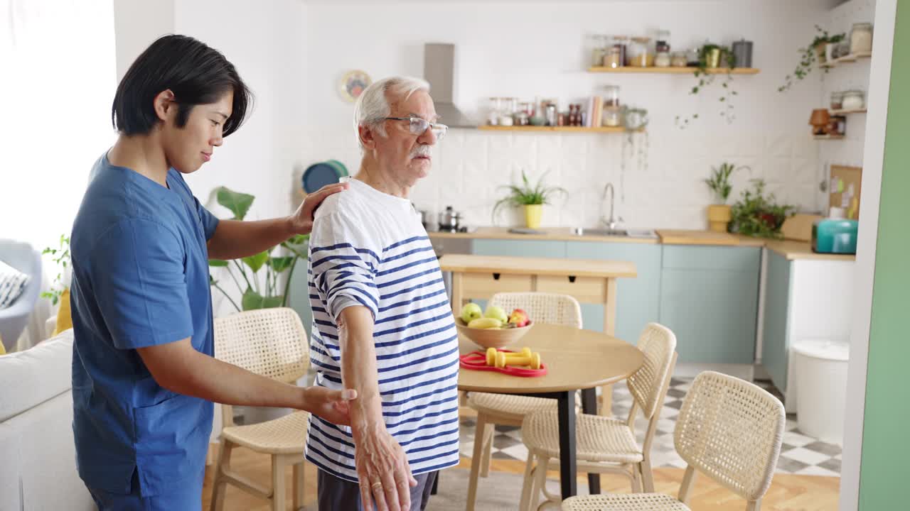 一位背部受伤的老人正在和他的理疗师一起康复视频下载