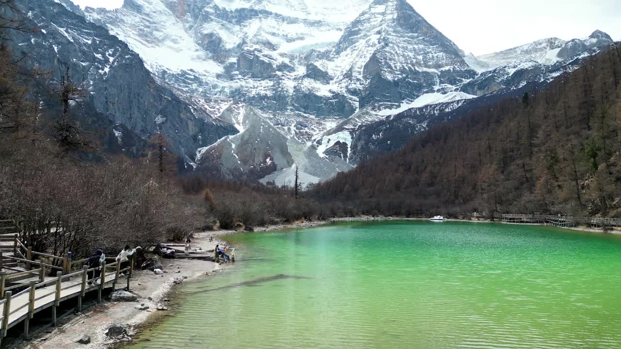 无人机拍摄的珍珠湖，以风景秀丽、令人叹为观止的亚丁自然保护区为背景的仙乃日山，位于中国四川甘孜藏族自治州视频素材