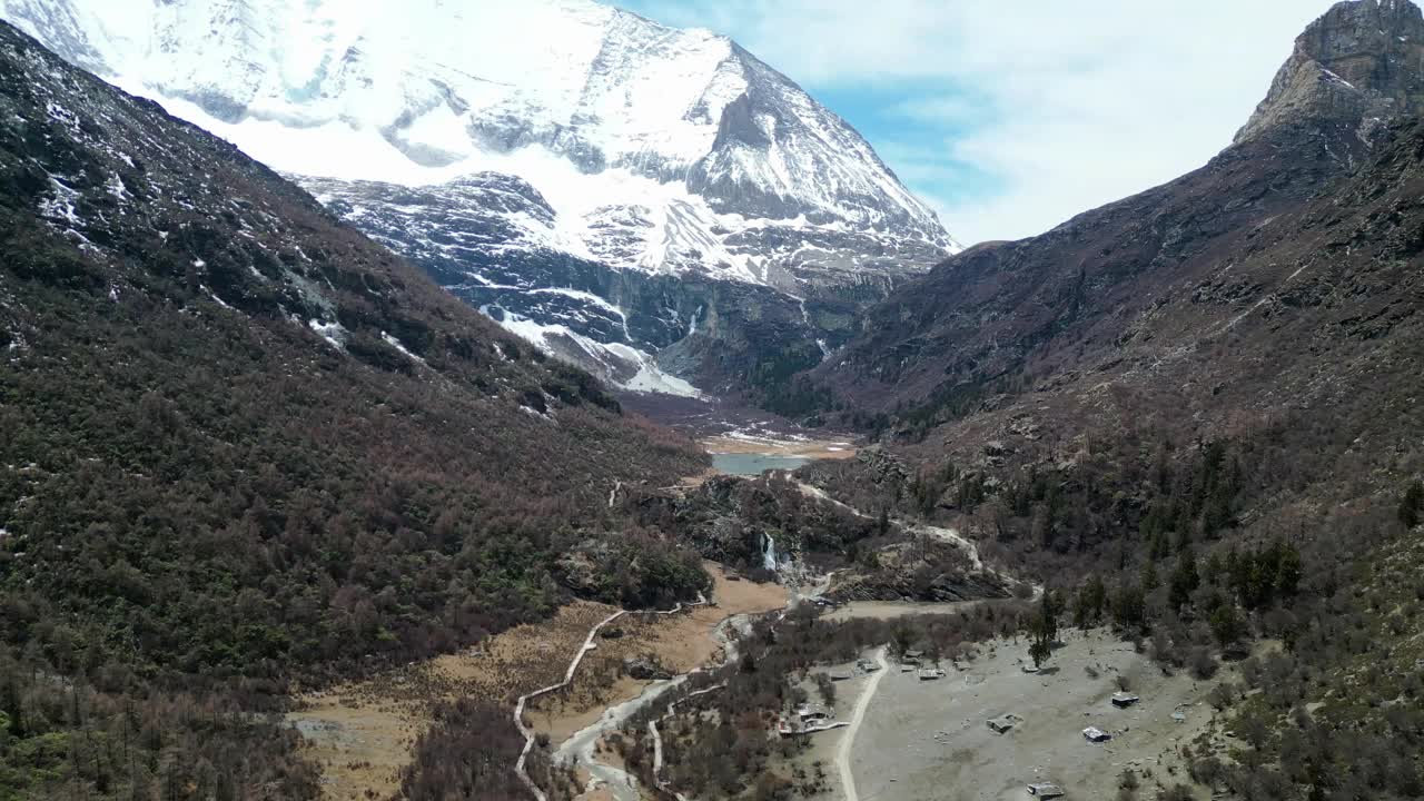 无人机拍摄的风景优美的亚丁自然保护区罗蓉牧场朝贡嘎湖，背景是杨麦涌山。位于中国四川。视频下载