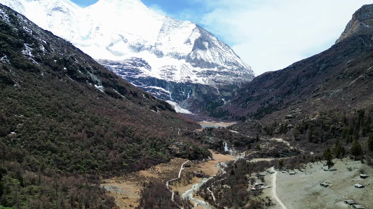 无人机拍摄的风景优美的亚丁自然保护区罗蓉牧场朝贡嘎湖，背景是杨麦涌山。位于中国四川。视频下载