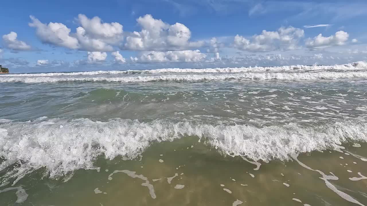 海浪拍打在沙滩上，沙滩上有沙子，泡沫，美丽的热带岛屿度假(卢基洛，波多黎各)游泳度假旅行加勒比海旅游(水上运动游泳涉水晒黑)海海浪视频下载