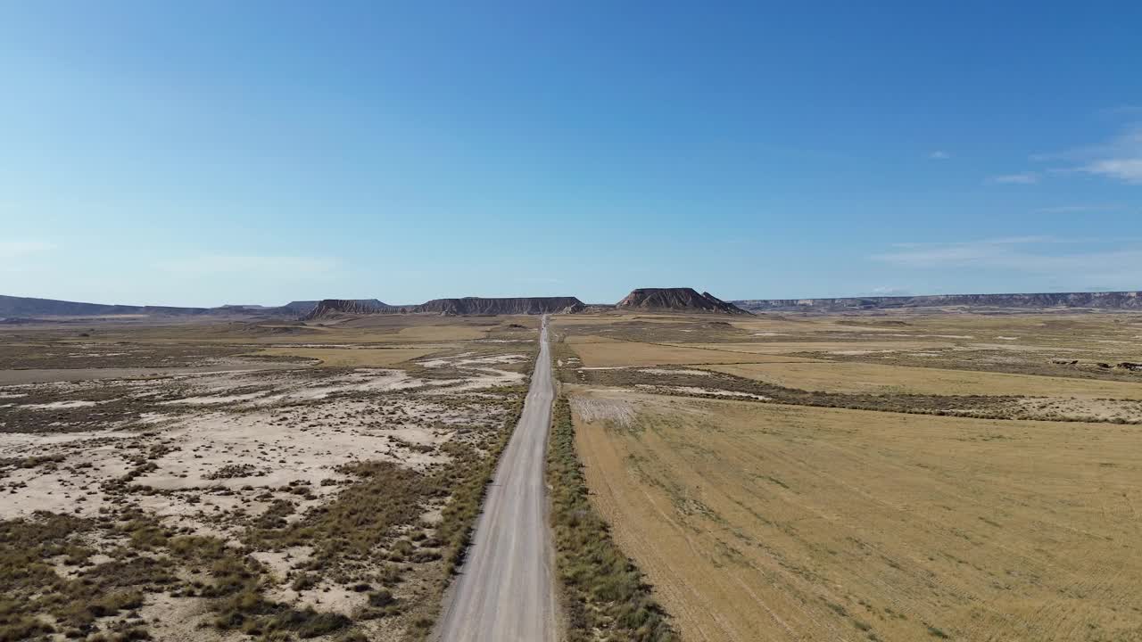 身穿白色长裙的黑发女子走在干燥平坦的道路上视频素材