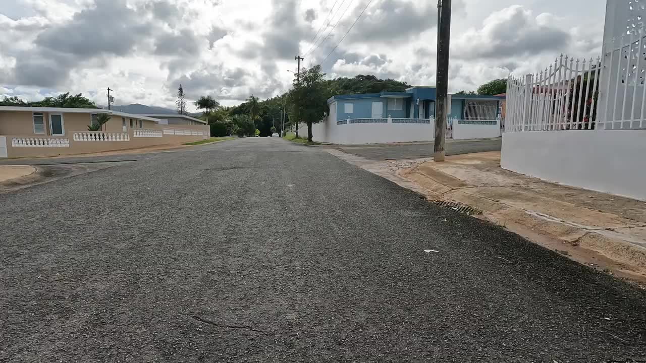 在波多黎各luquillo(热带加勒比海海滩小镇)住宅区的郊区，骑着一条小铺砌的道路视频下载