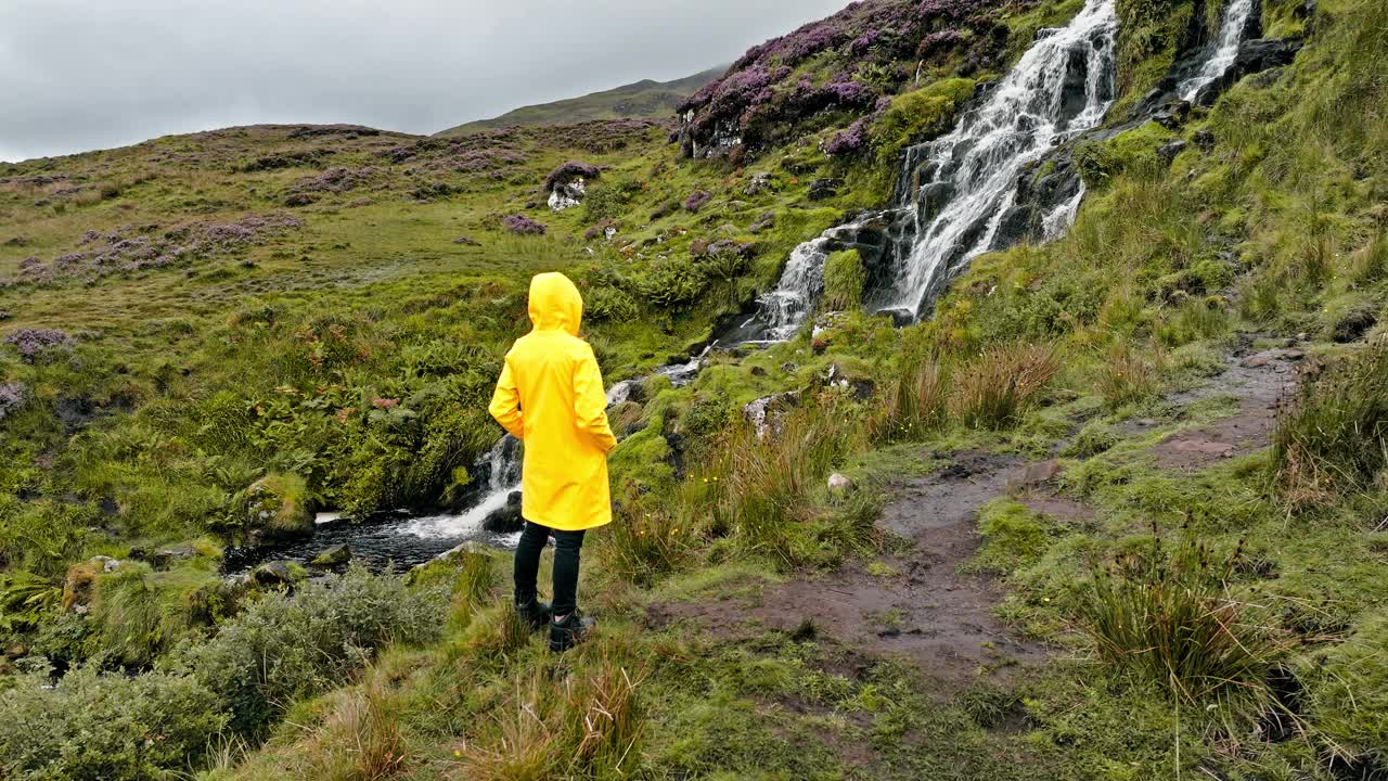 一名游客在苏格兰高地欣赏瀑布的鸟瞰图。视频下载