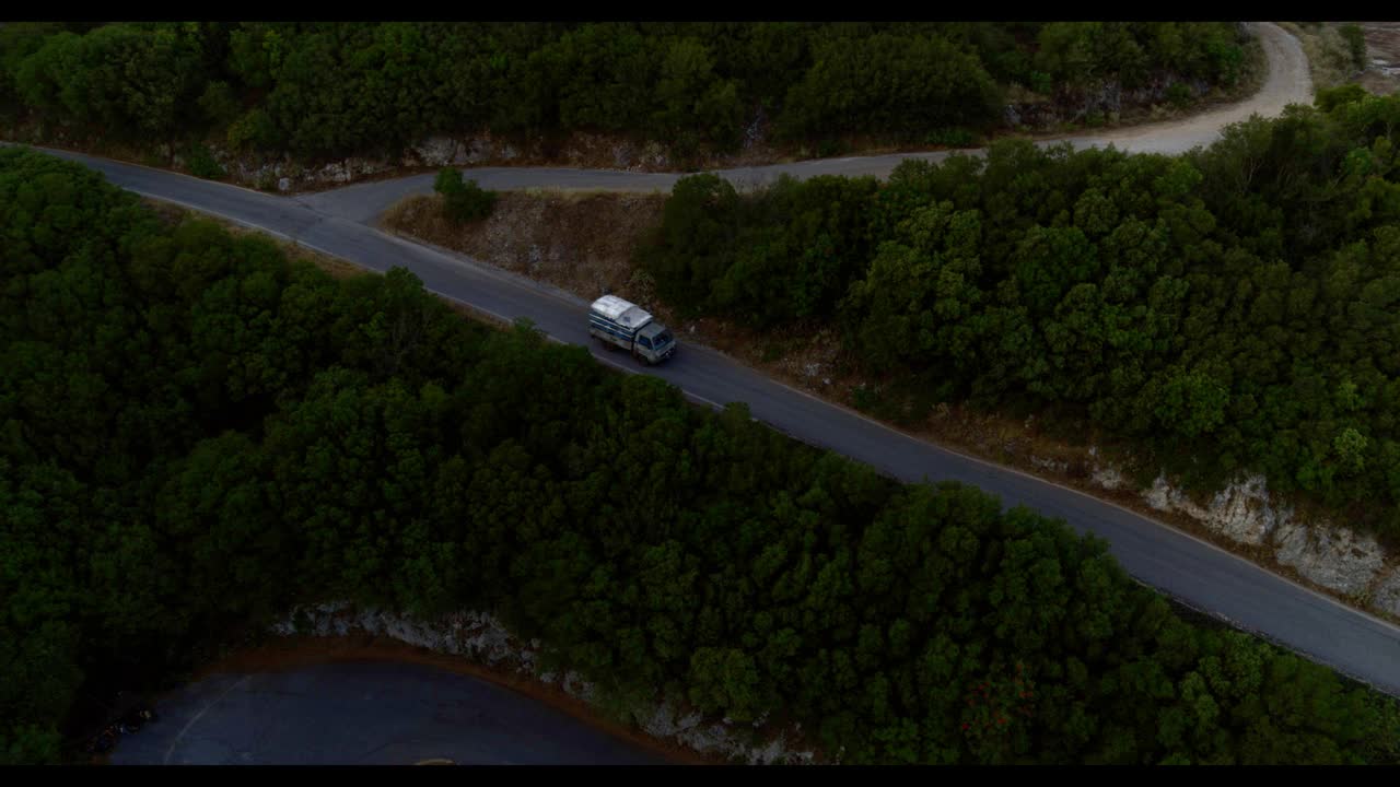 空中向下的角度，旧卡车在曲折的道路上，使发夹转弯，向前到山上雅典，希腊视频素材