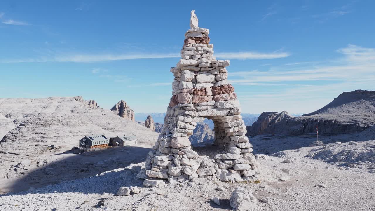 白云石，意大利阿尔卑斯山。前景中石头上的土堆和背景中的rifugio Boe小屋。去皮兹波徒步旅行。萨拉地块视频下载