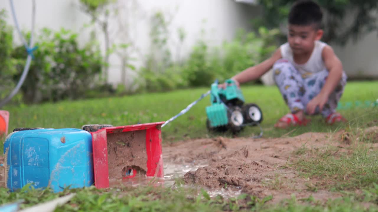 孩子们在院子里玩玩具自卸卡车。视频下载