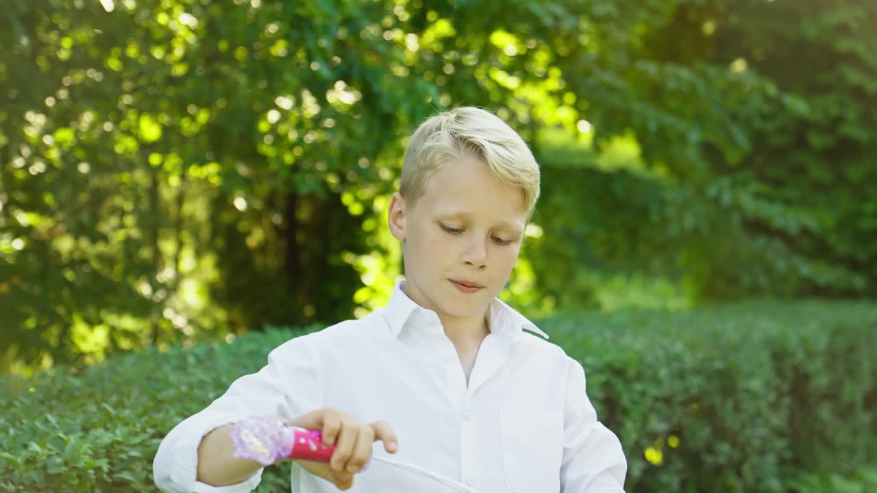 吹肥皂泡的帅哥玩得很开心。孩子在户外玩耍视频下载