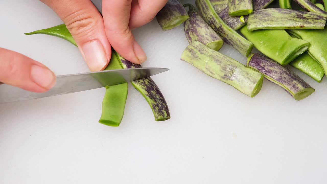 妇女双手切青豆。自制食物。视频下载