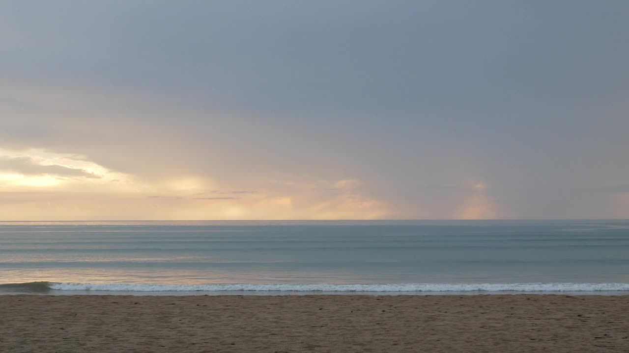 自然景观戏剧性的日落在海面上的海滩表面，在日落的时间与许多云在傍晚的天空。视频下载