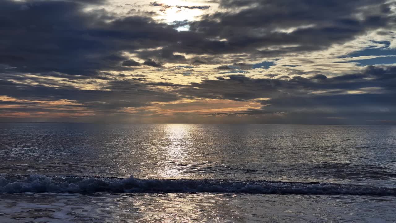 热带金色的日落在海水上慢动作鸟瞰图。落日在海景上的倒影。视频素材