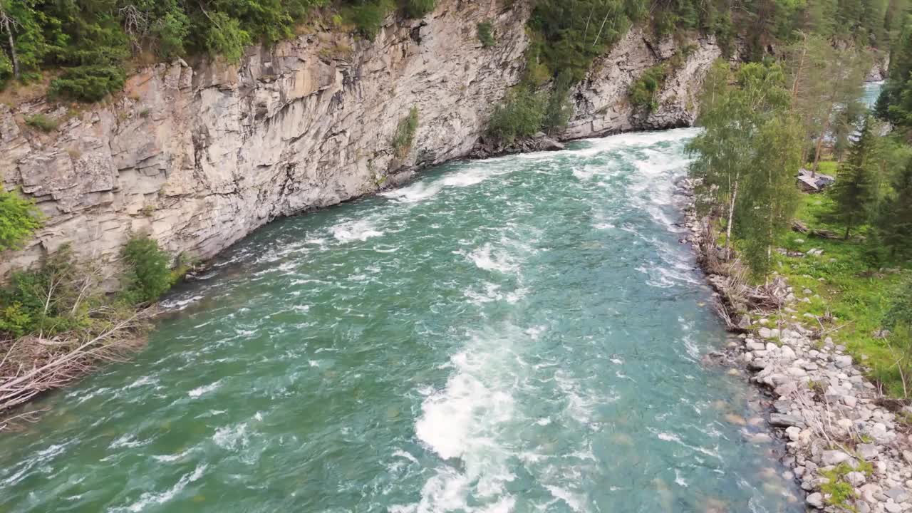 鸟瞰图，一条湍急的河流穿过岩石峡谷，周围是郁郁葱葱的树木和天然的绿色植物。视频素材