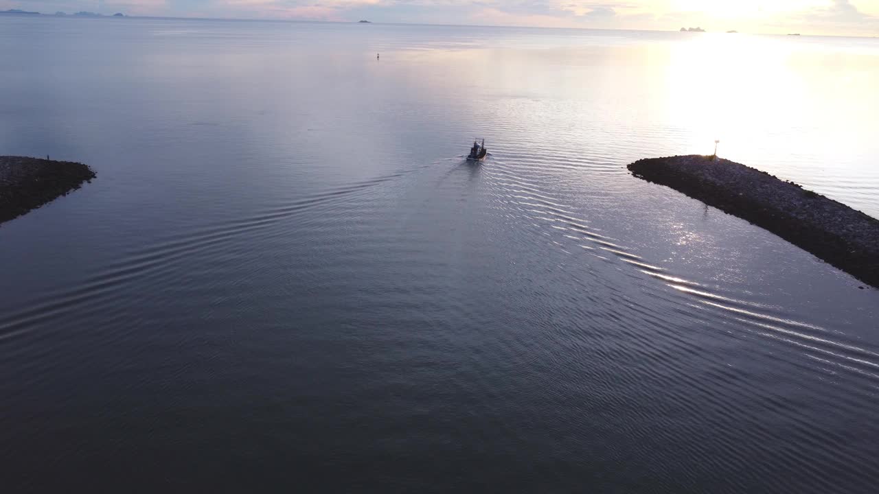 鸟瞰清澈碧绿的大海，一艘孤独的渔船在泰国北南春蓬镇制造泡沫水道。视频素材