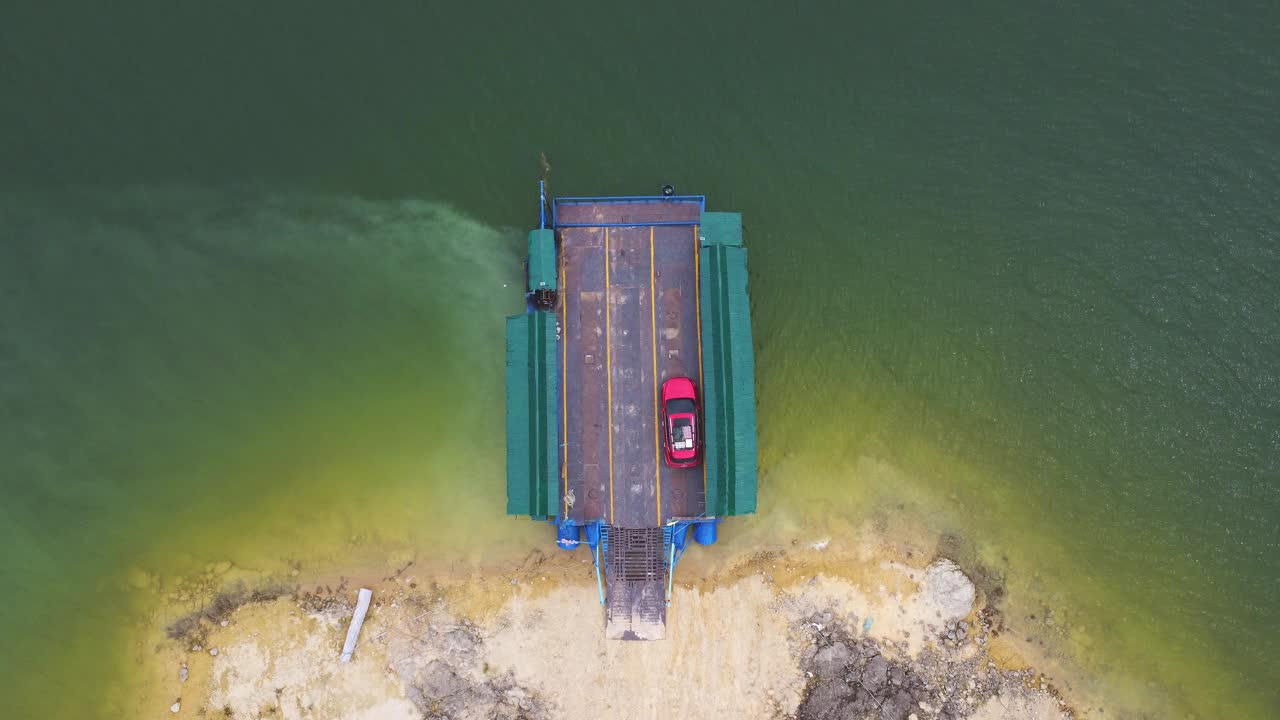 鸟瞰泰国北碧府当地运送汽车、摩托车和人过河的渡轮。视频素材