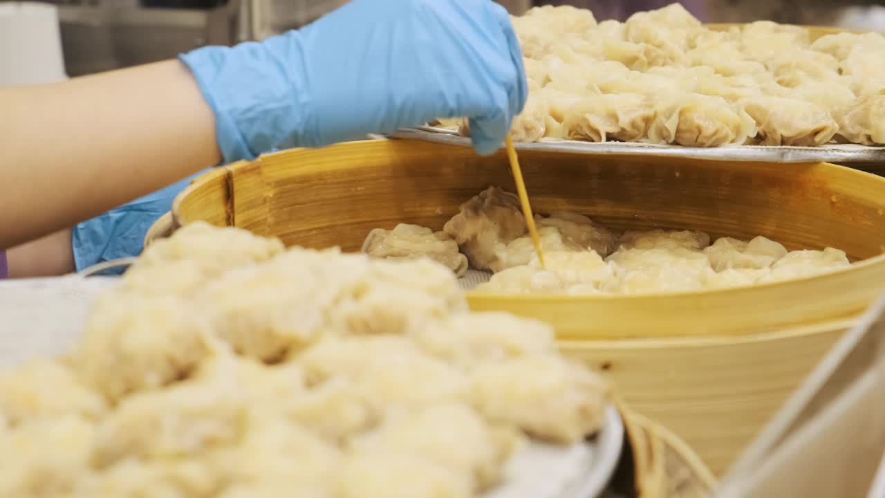 小贩在夜市烹煮泰国街头小吃出售。鸡肉饺子特写。泰国曼谷的亚洲美食。中国菜视频下载