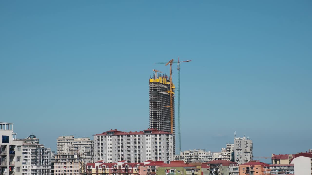 摩天大楼正在建设，起重机映衬着蓝天。新建高层建筑施工现场。城市的发展和成长。间隔拍摄视频下载