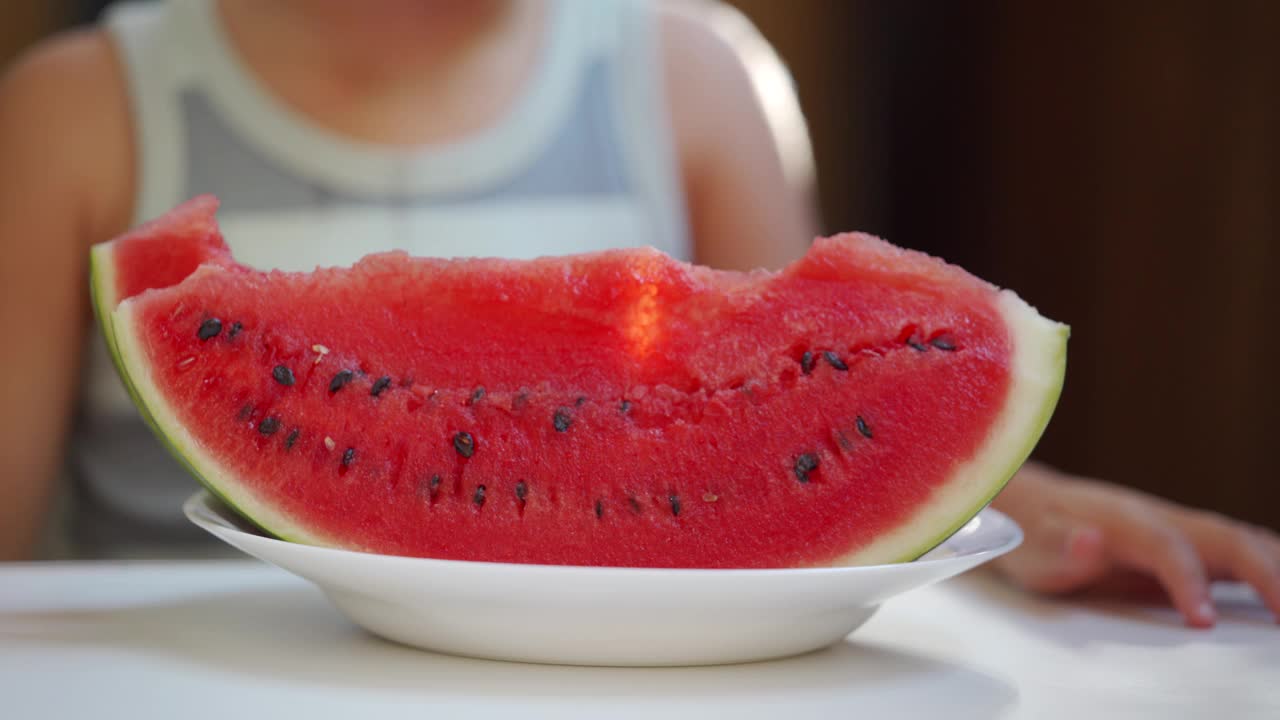 夏天，小孩子坐在阳台上吃西瓜视频素材