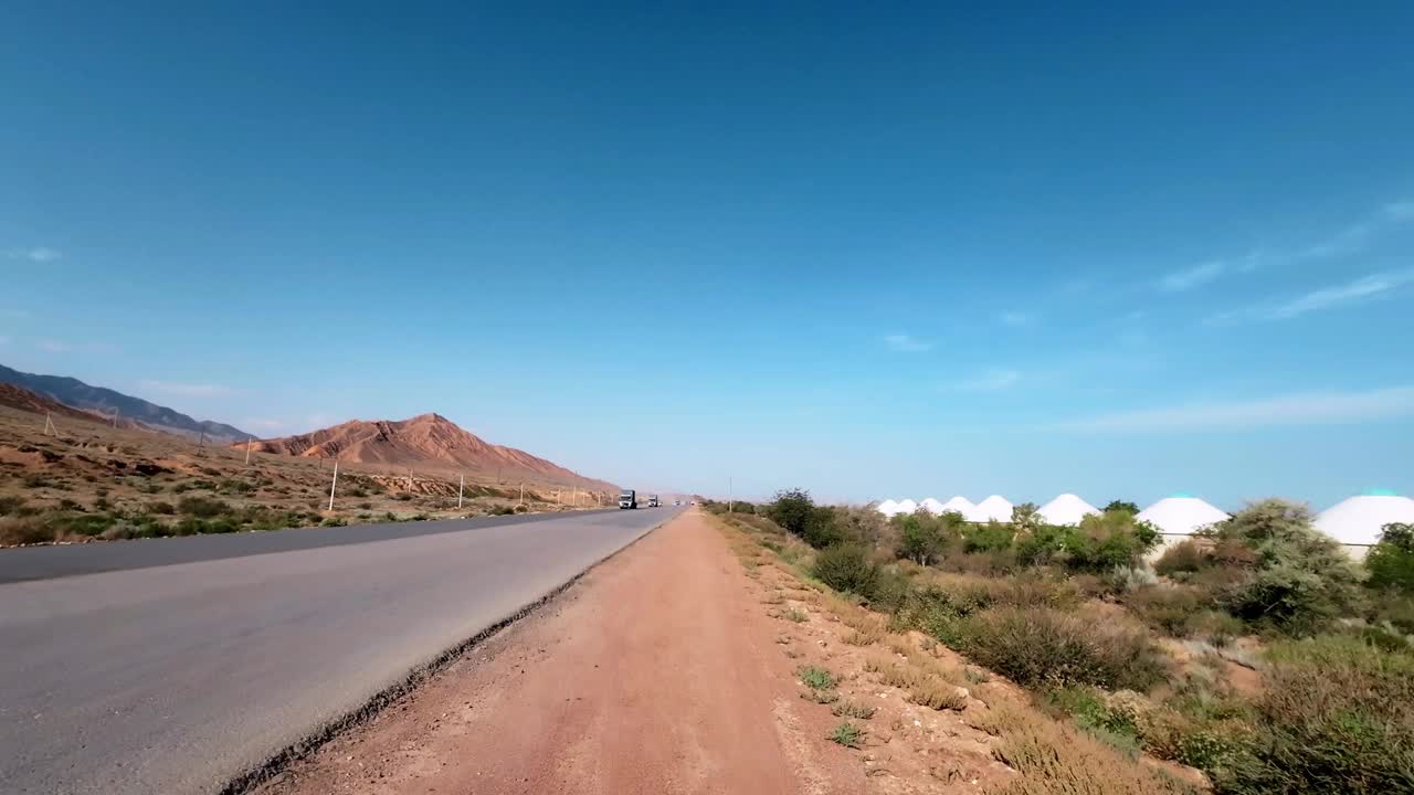 从蒙古包营地看中亚道路上的交通视频下载