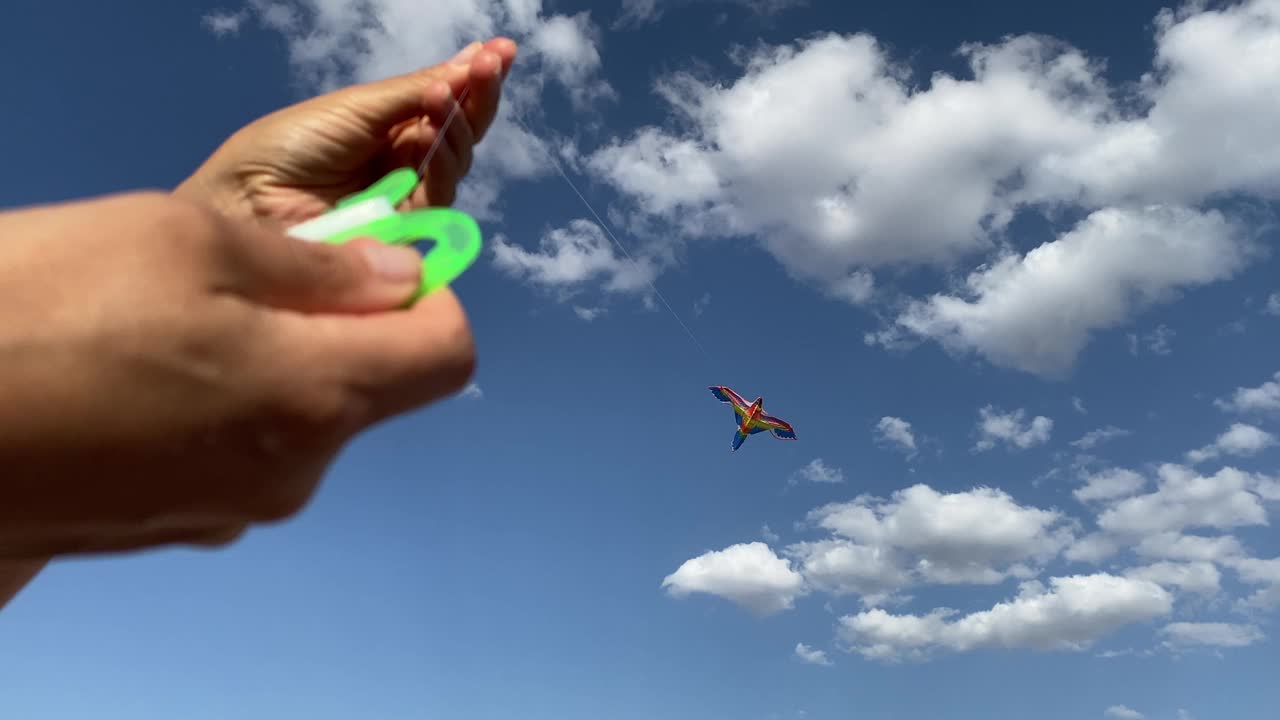 五颜六色的风筝在晴空万里的天空中飞舞，女子在大自然中放飞风筝视频素材