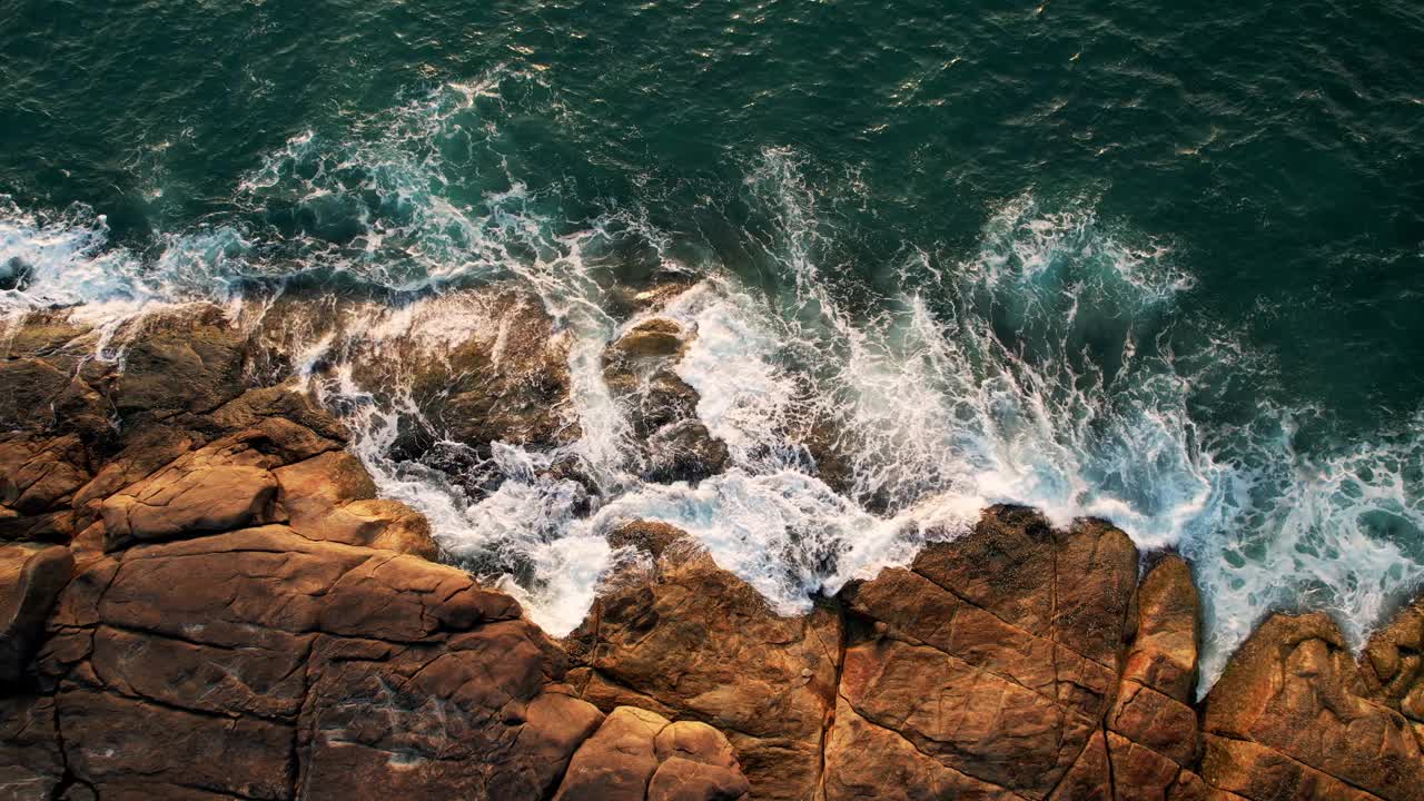 海浪撞击岩石和激流旋转，鸟瞰图。视频素材