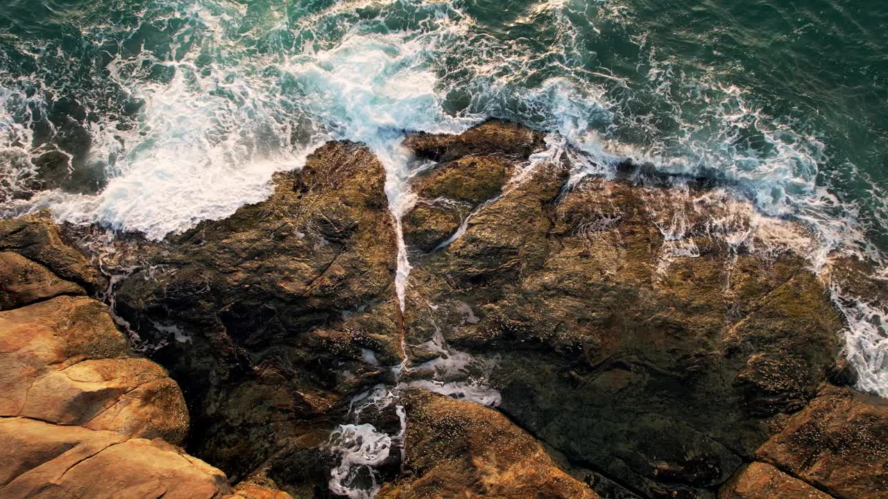 鸟瞰海浪撞击岩石的画面。视频下载