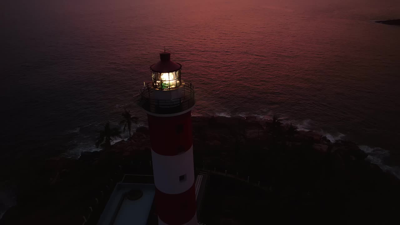 海岸线上有光束的灯塔，鸟瞰图。Kovalam海滩，印度喀拉拉邦。视频下载