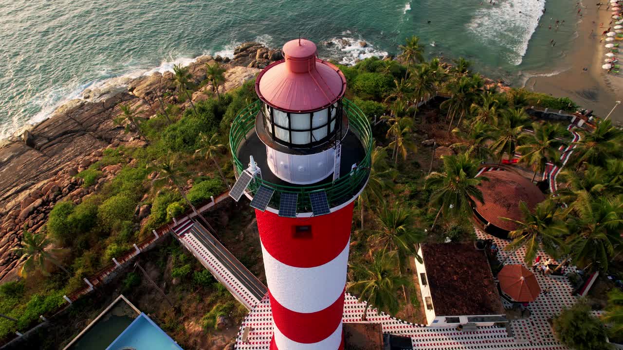 日落时海上海岸线上的灯塔，鸟瞰图。印度喀拉拉邦的Kovalam海滩和灯塔。视频素材