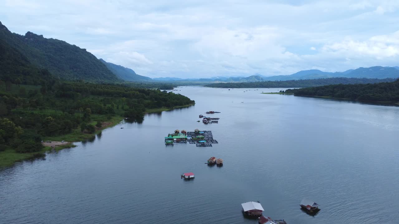 泰国北碧府桂河和水上房屋的鸟瞰图。美丽的漂浮小屋和在桂河上航行的泰国长尾船。视频下载