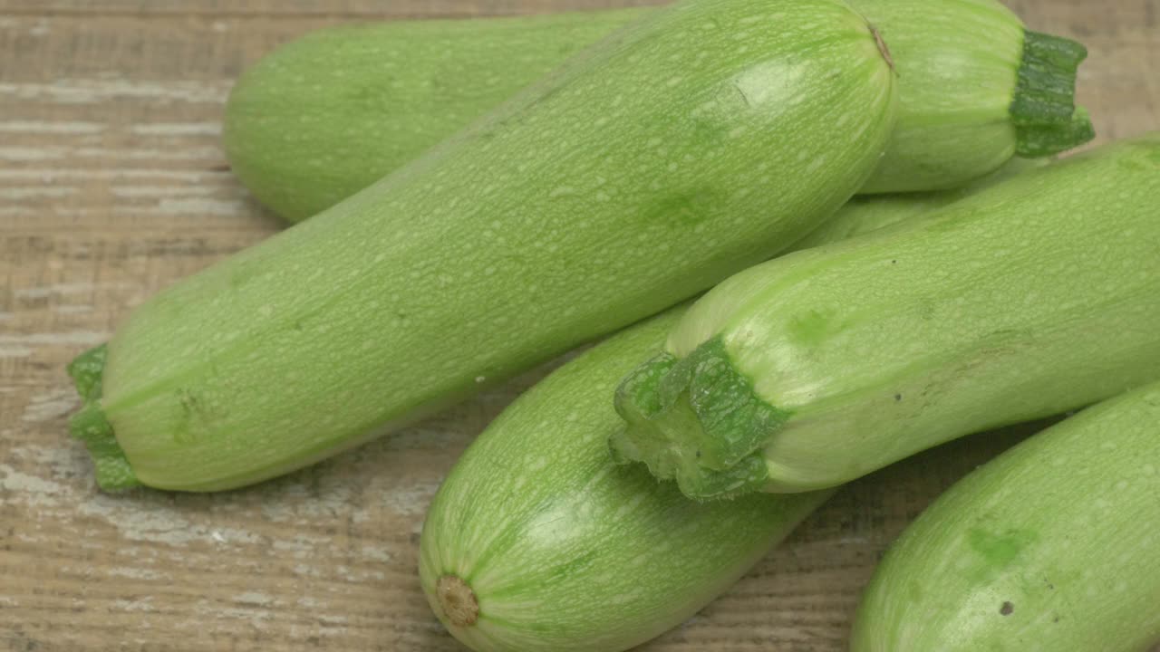 鲜亮新鲜的西葫芦蔬菜漂亮地摆放在质朴的木质表面上视频素材