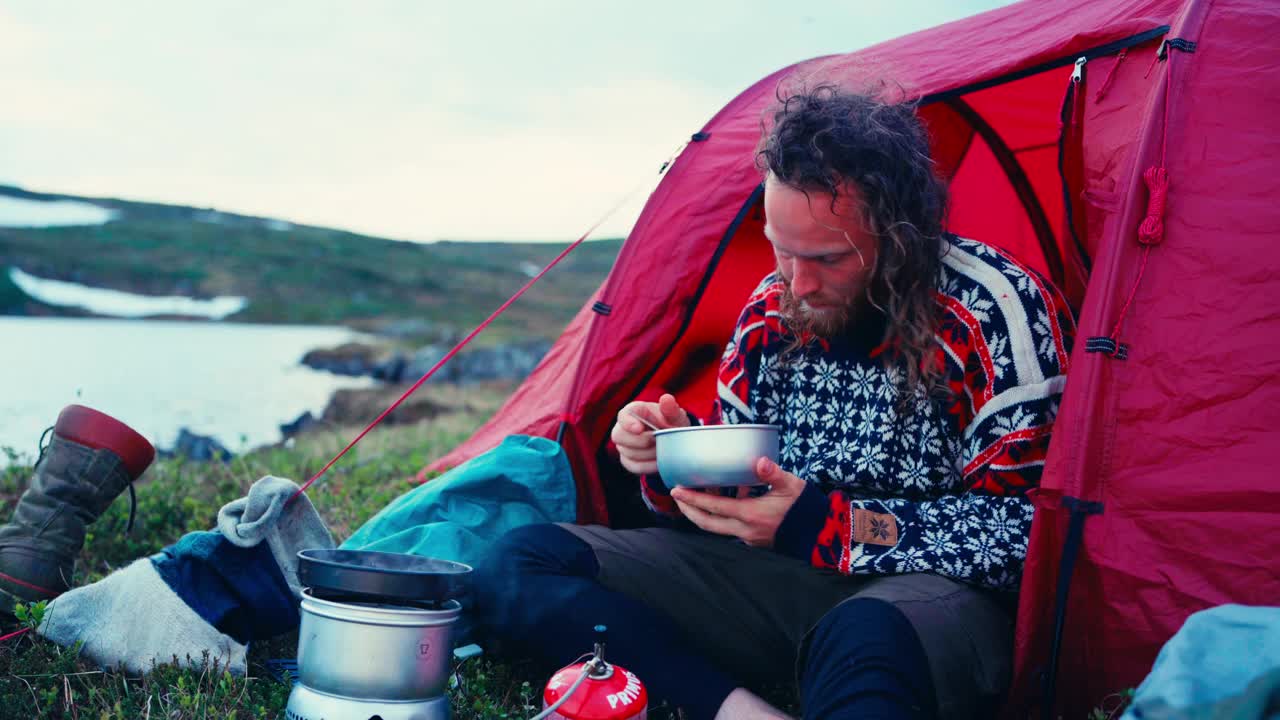 一名男子正在Mefjelsvatnet湖边露营，在挪威特恩德拉格因德福森斯库文附近视频素材