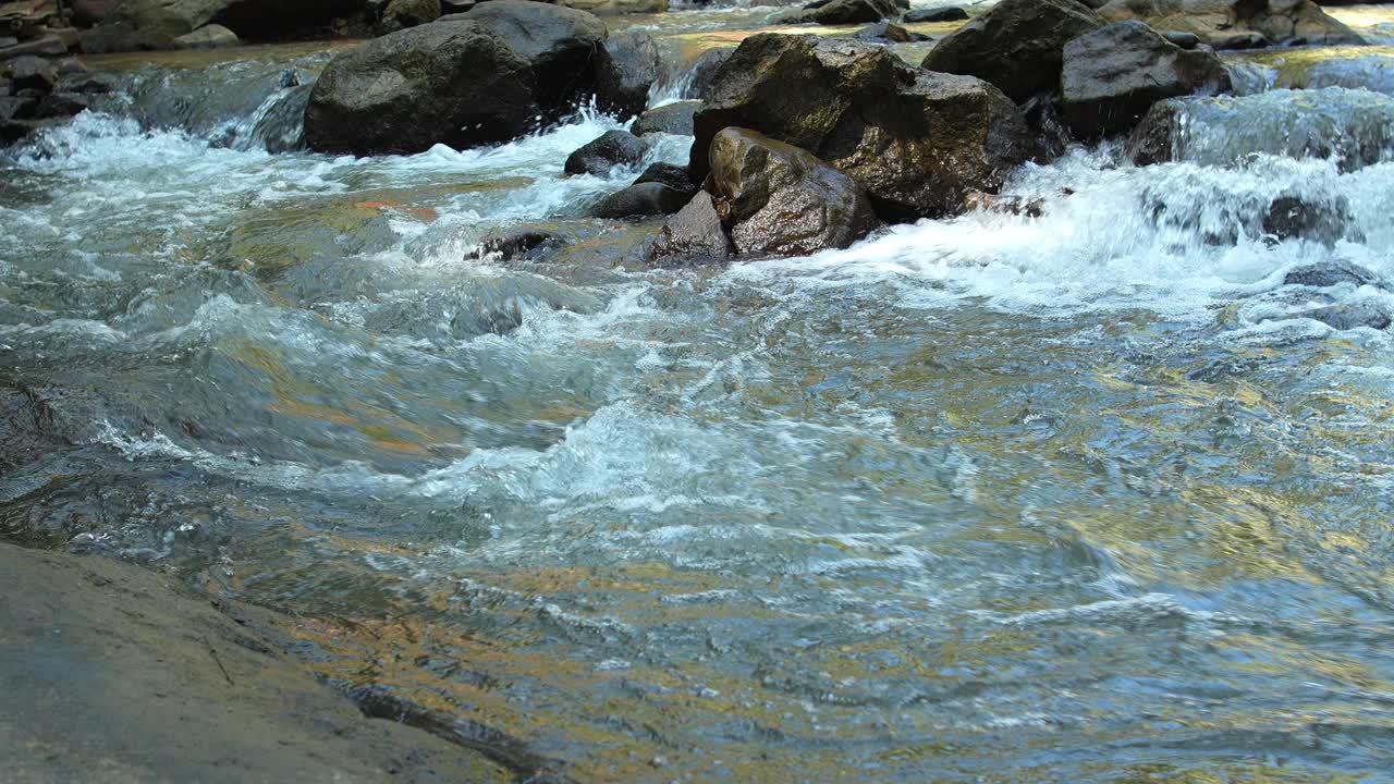 水面从天然溪流流过，流过天然岩石，看起来清爽。视频素材