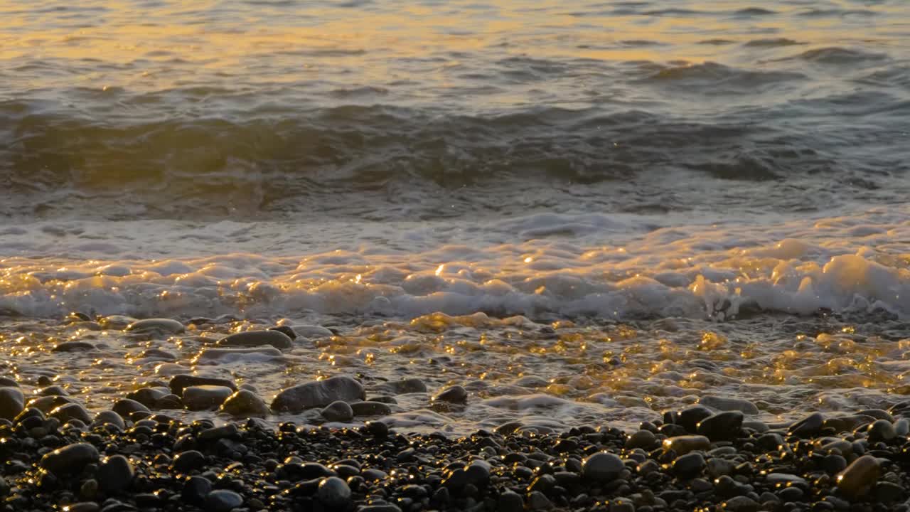 慢镜头——海浪冲击卵石滩——近距离拍摄视频素材