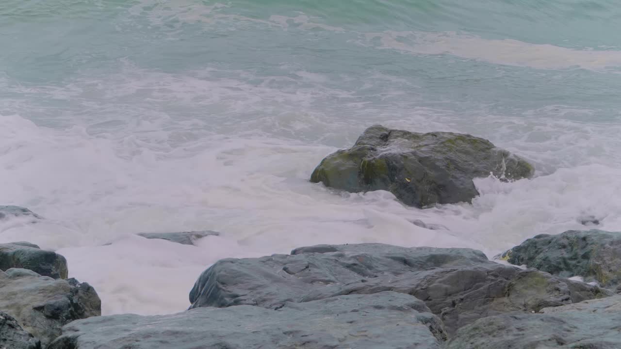 慢镜头——海浪冲击着石岸的岩石——近距离拍摄视频下载