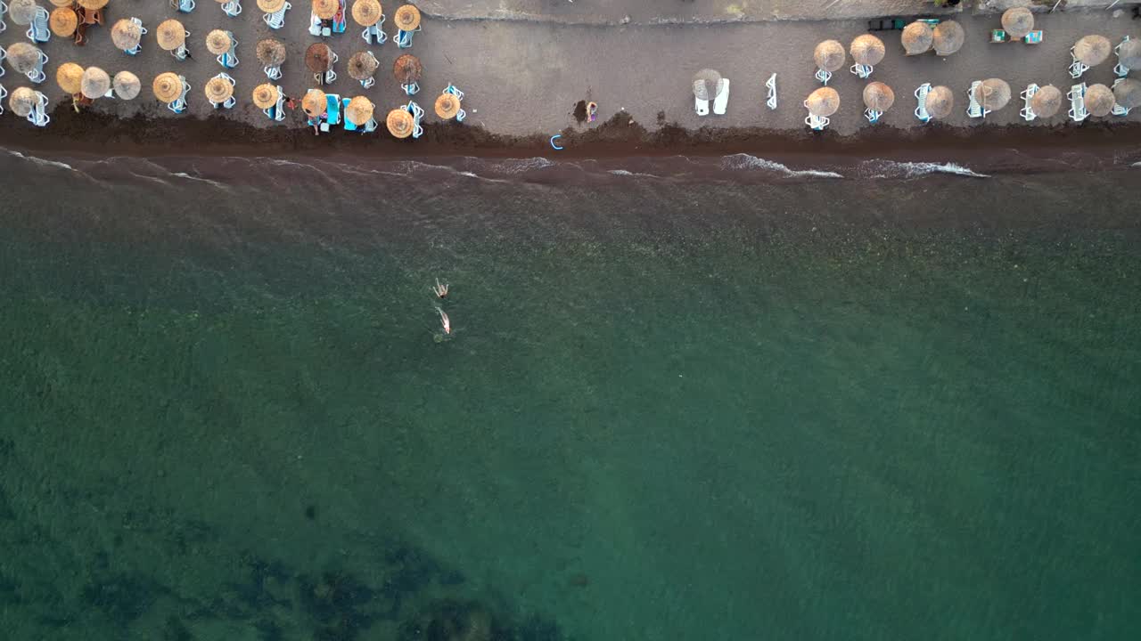 鸟瞰海滩和几个人。视频下载