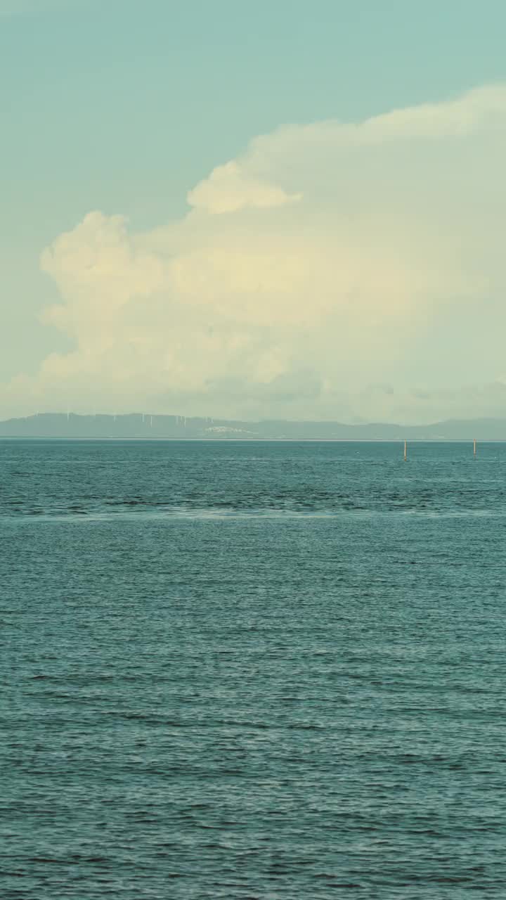 戏剧性的雷雨或积雨云漂浮在海上在夏天，户外或旅行，暑假，垂直视频的智能手机镜头视频素材