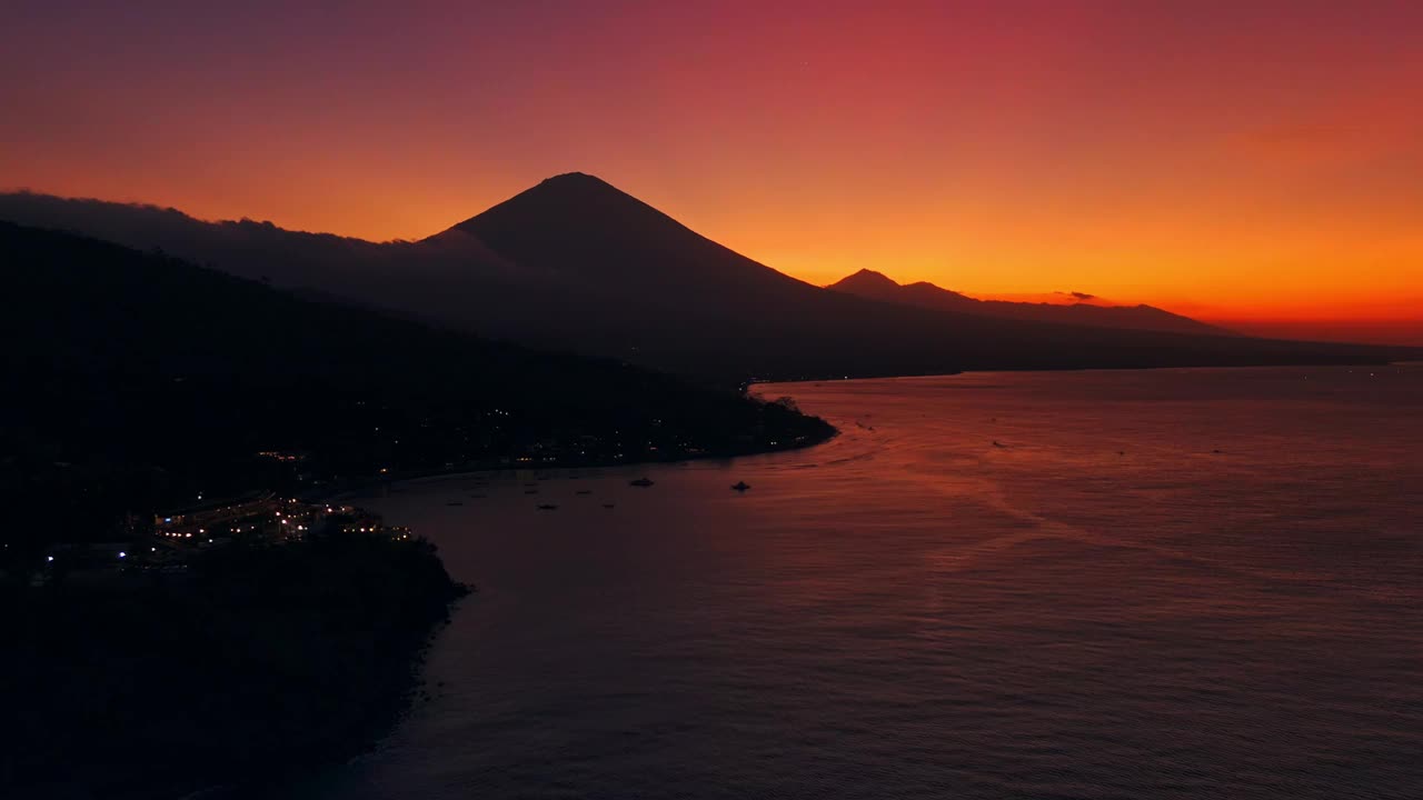 海岸线和火山山在明亮的日落。无人机拍摄的巴厘岛阿米德视频下载