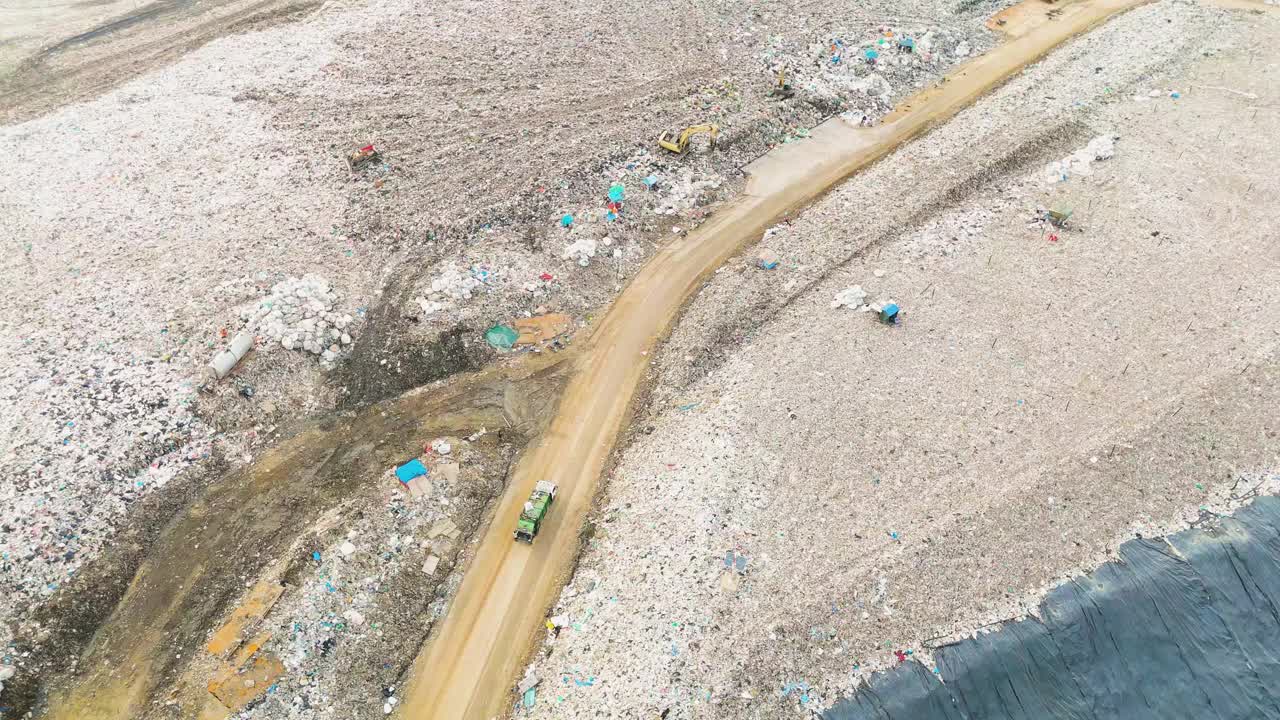 鸟瞰垃圾填埋场，垃圾车正在卸载垃圾视频下载