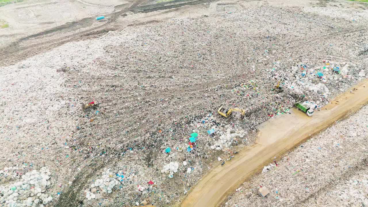 鸟瞰垃圾填埋场，垃圾车正在卸载垃圾视频素材