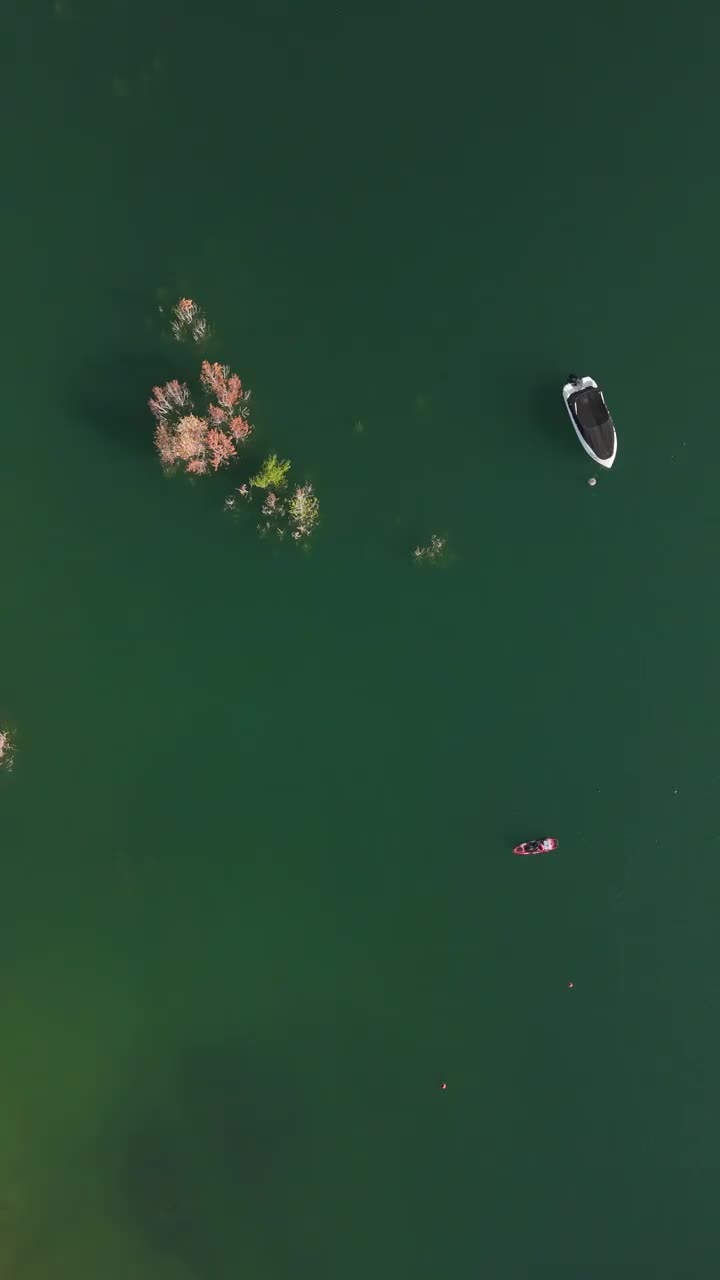 宁静的场景:渔夫在独木舟上清澈的绿松石湖视频下载