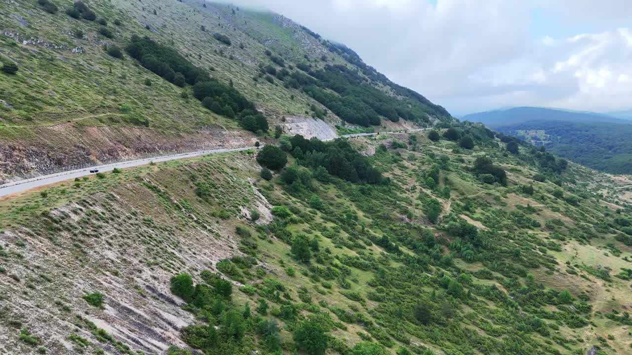 蜿蜒的山路穿过郁郁葱葱的绿色景观在清晨的雾视频素材