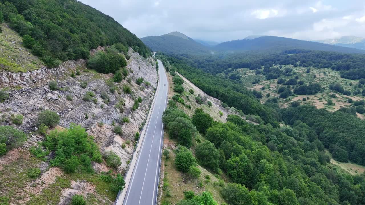 令人惊叹的鸟瞰图，蜿蜒的道路穿过郁郁葱葱的青山在晚春视频素材