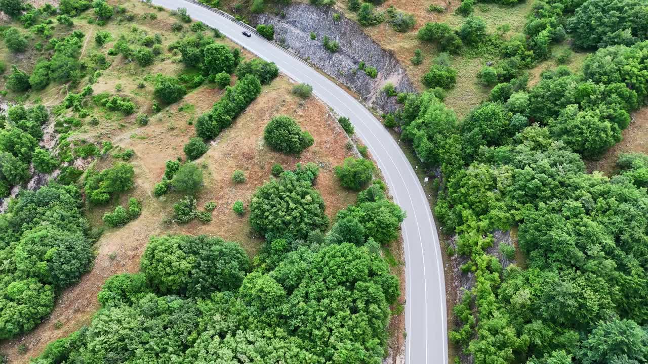 迷人的鸟瞰图宁静的道路被郁郁葱葱的绿色植物和岩石地形包围视频素材