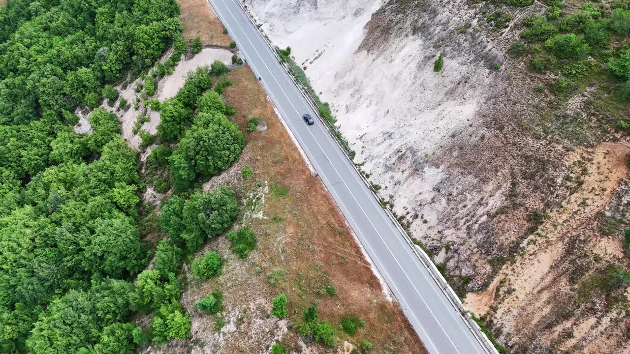 迷人的鸟瞰图宁静的道路被郁郁葱葱的绿色植物和岩石地形包围视频素材