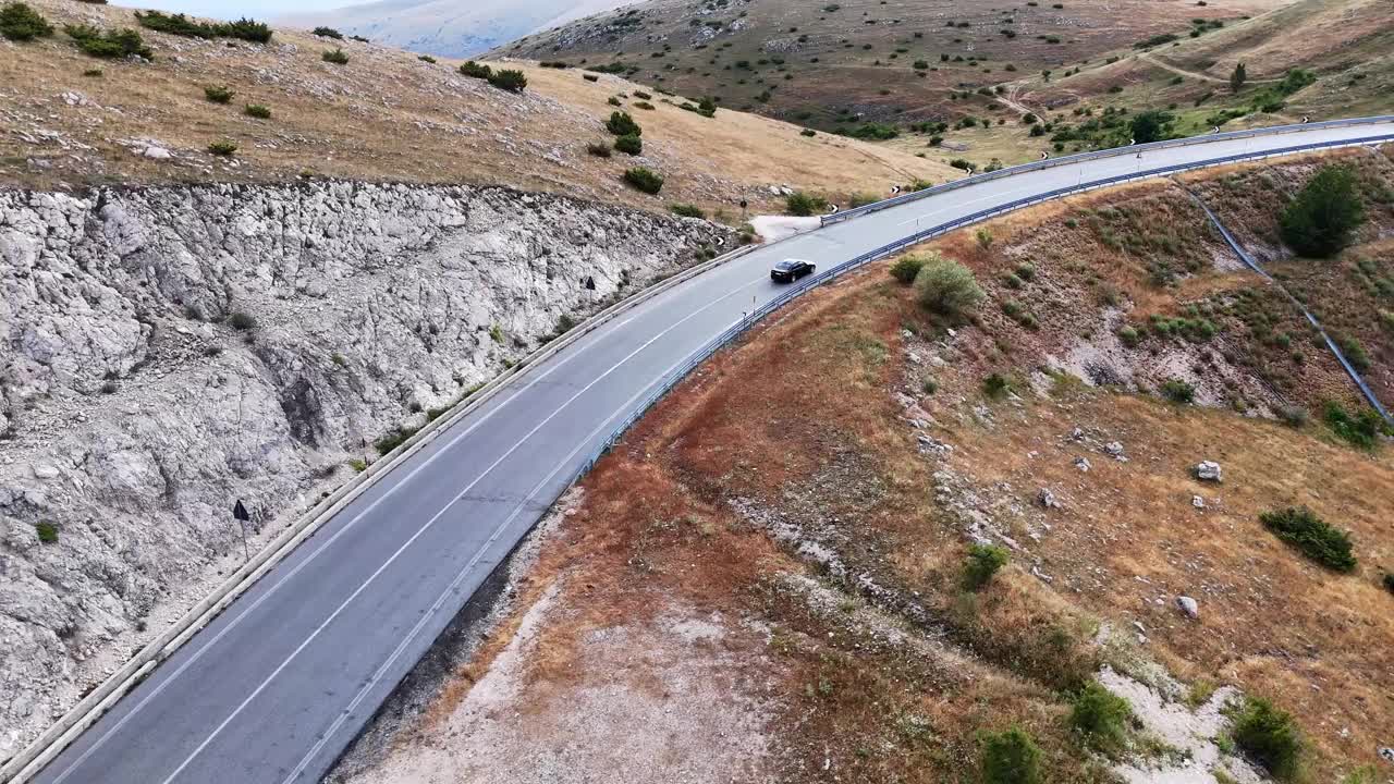 弯弯曲曲的山路环绕着傍晚蓝天下的风景视频素材