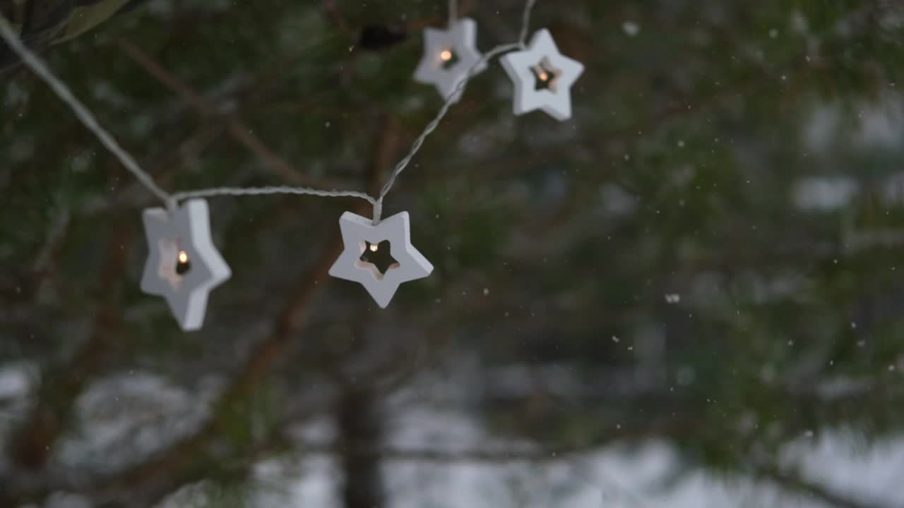 圣诞彩灯挂在常青树松树。冬天常绿的冷杉树枝和许多飘落的雪尘。降雪超级慢动作。白雪皑皑的云杉。自然背景视频片段视频素材