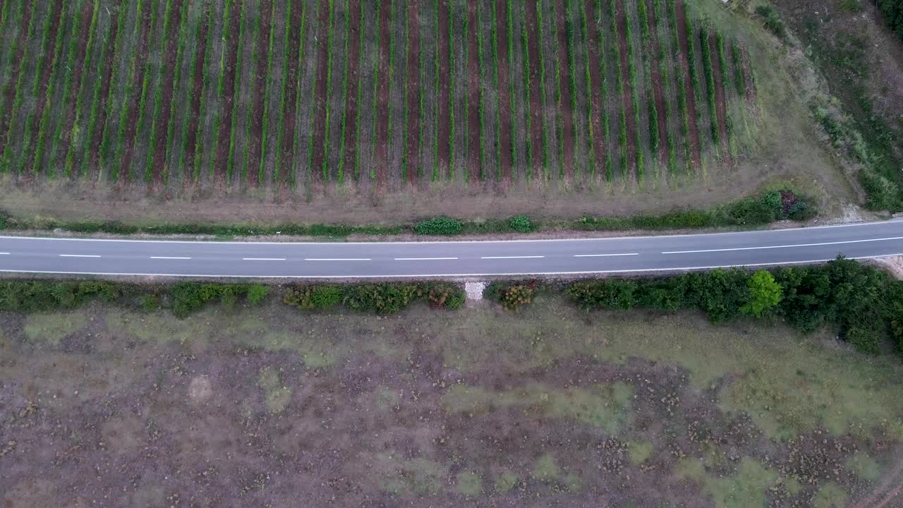 鸟瞰图:汽车沿着山脚下的道路移动视频下载