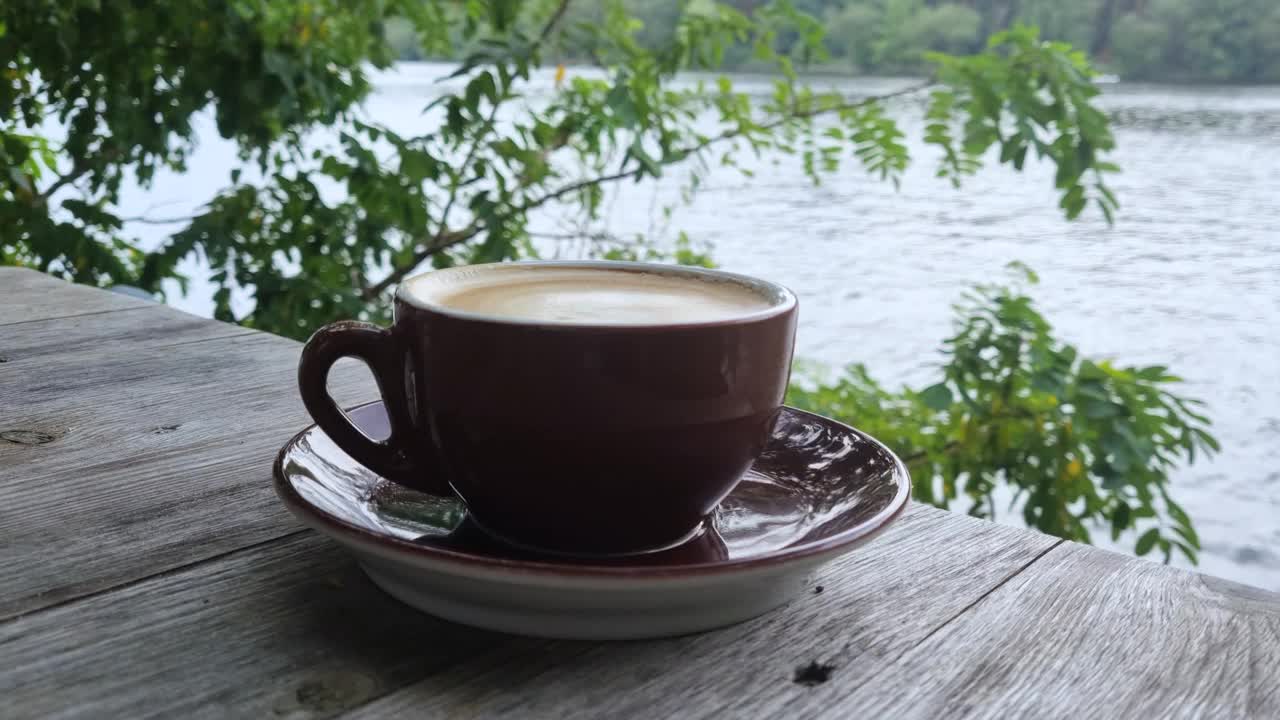 咖啡杯放在木平台上，旁边是山与山之间的湖视频下载