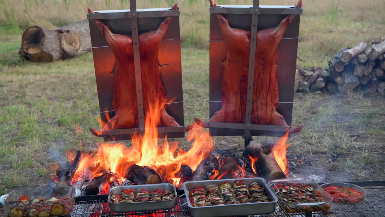 传统的阿根廷asado，羊肉和小猪在柴火上慢炖，刷上辛辣的墨西哥辣酱视频素材